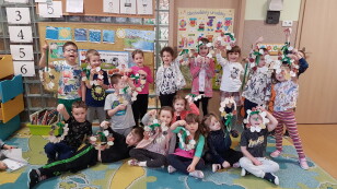 Dzieci z grupy Smerfy prezentujące dekoracje wielkanocne wykonane na warsztatach plastycznych.